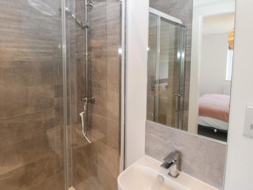 La salle de bains est pourvue d'une douche et d'un lavabo. dans l'établissement Dune Retreat, à Rhosneigr