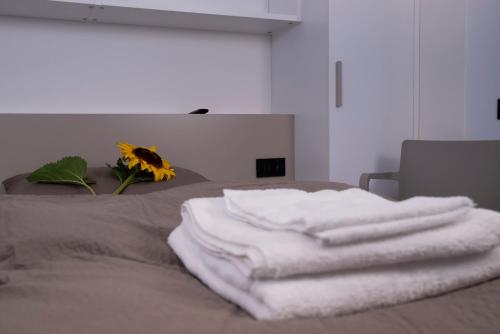 a pile of towels sitting on top of a bed at SILVANELLO Apartment in Trento