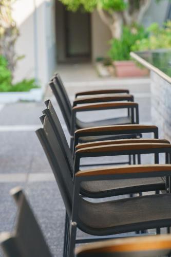 a row of black chairs sitting on a patio at Kos Palace in Tigaki