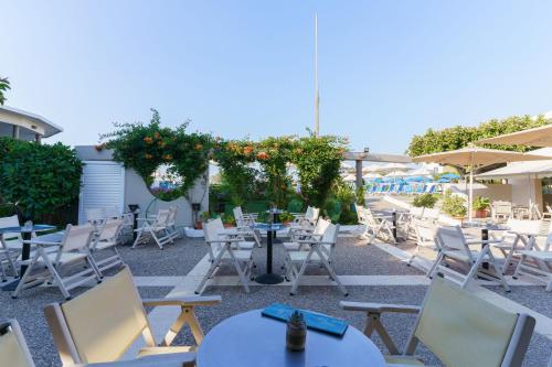 a patio with chairs and tables and an umbrella at Kos Palace in Tigaki