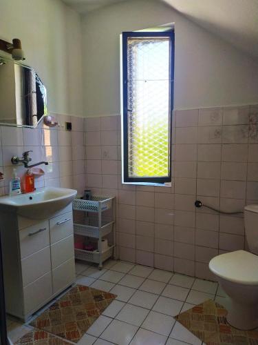 a bathroom with a sink and a toilet and a window at Penzion Renata in Třeboň