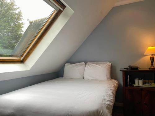 a bed in a room with a window at Shrigley Hall Hotel in Macclesfield