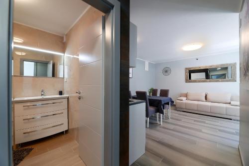 a bathroom with a sink and a living room at Villa Mariella in Novalja