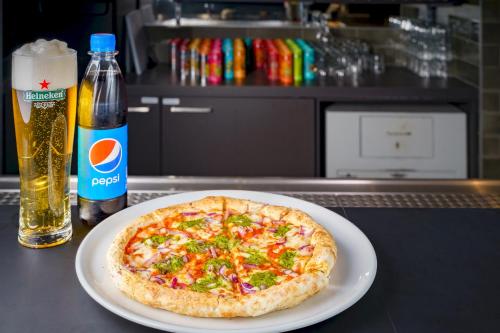 a pizza sitting on top of a counter next to a bottle of beer at a&o Copenhagen Sydhavn in Copenhagen