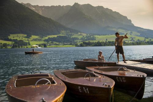 a man standing on a dock with boats on a lake at Kaiser Apart Walchsee in Walchsee