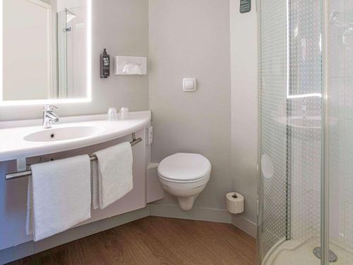 La salle de bains est pourvue de toilettes, d'un lavabo et d'une douche. dans l'établissement ibis Brussels Waterloo, à Waterloo