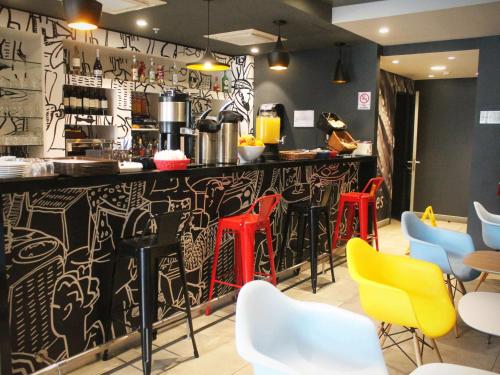 a restaurant with a bar with colorful chairs at ibis Iquique in Iquique