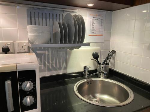 um balcão de cozinha com um lavatório e um micro-ondas em Phoenix Plaza Hotel Apartments em Abu Dhabi