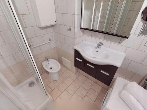La salle de bains blanche est pourvue d'un lavabo et de toilettes. dans l'établissement Studio Menton, 1 pièce, 3 personnes - FR-1-196-224, à Menton