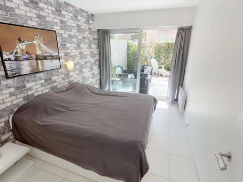 a bedroom with a bed and a brick wall at Appartement Menton, 2 pièces, 4 personnes - FR-1-196-164 in Menton