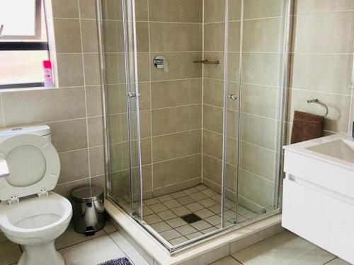 a bathroom with a shower and a toilet at The Blyde Crystal lagoon Pretoria in Pretoria