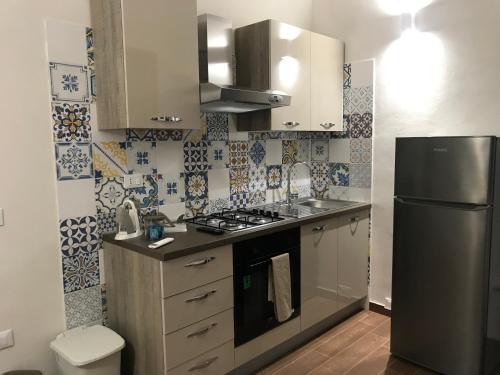 a small kitchen with a stove and a refrigerator at Case vacanze Spagnola 106 in Marsala