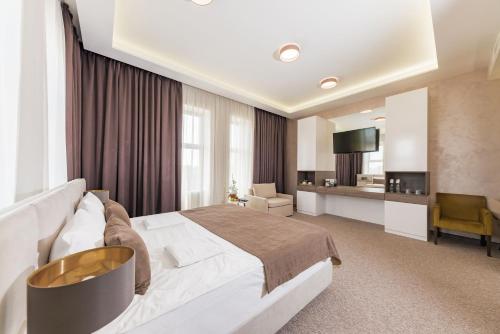 a hotel room with a large bed and a television at WISH Aqua&SPA Resort in Vishenki