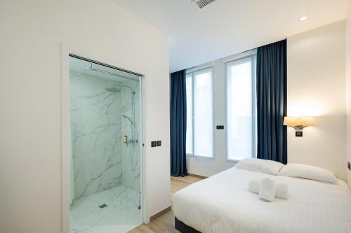 a white bedroom with a shower and a bed at HOTEL AU COEUR DES ARTS ET METIERS in Paris