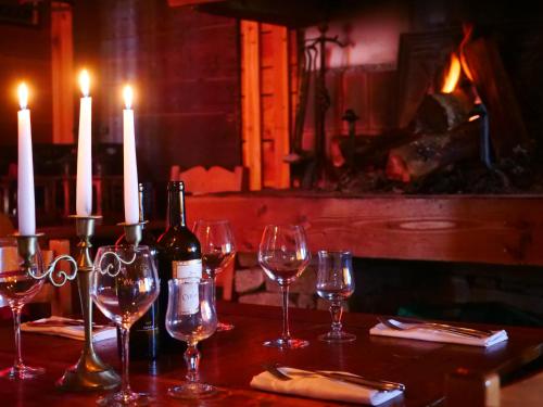 a table with wine glasses and candles on it at Doume's Lodge in Les Deux Alpes