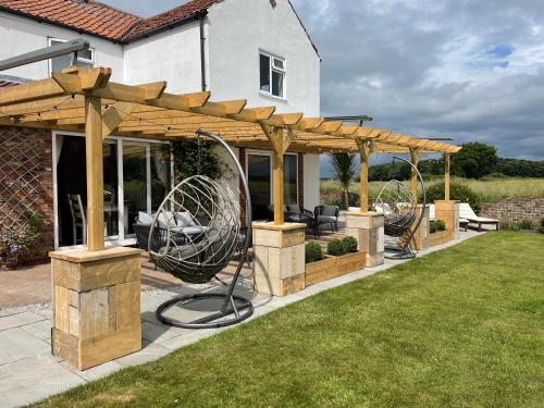 a wooden pergola in the backyard of a house at Deighton Lodge in York