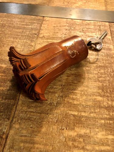 a wooden bottle opener with a pair of keys at Hôtel Saint Louis in Aigues-Mortes
