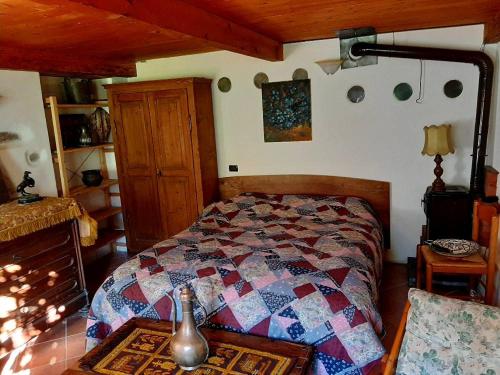 a bedroom with a bed with a quilt on it at Piccola oasi nella frescura delle Alpi tra verdi boschi e sorgenti di acqua purissima in Vanzone