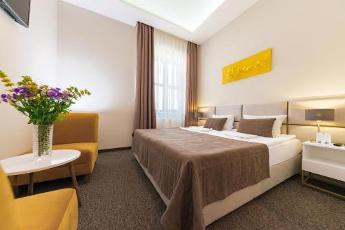 a hotel room with a bed and a vase of flowers at WISH Aqua&SPA Resort in Vishenki