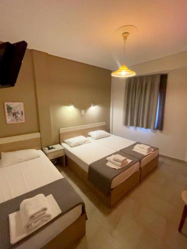 a hotel room with two beds and a window at Afrodite Beach in Nei Poroi