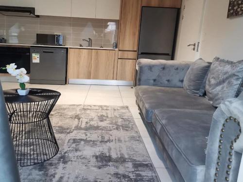 a living room with a couch and a table at The Blyde Crystal lagoon Pretoria in Pretoria