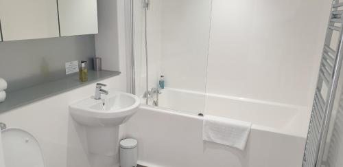 a white bathroom with a sink and a shower at Quay Apartments Exchange Quay in Manchester