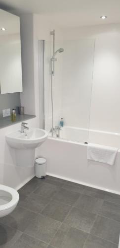 a bathroom with a sink and a tub and a toilet at Quay Apartments Exchange Quay in Manchester