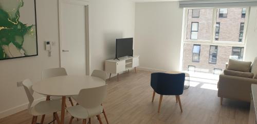 a living room with a table and a tv and a couch at Quay Apartments Exchange Quay in Manchester