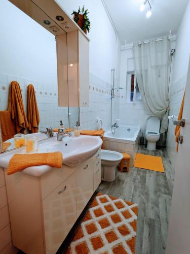 ein Badezimmer mit zwei Waschbecken, einer Badewanne und einem WC in der Unterkunft Casa Vacanza Due Elle - Casa Margherita in Triest