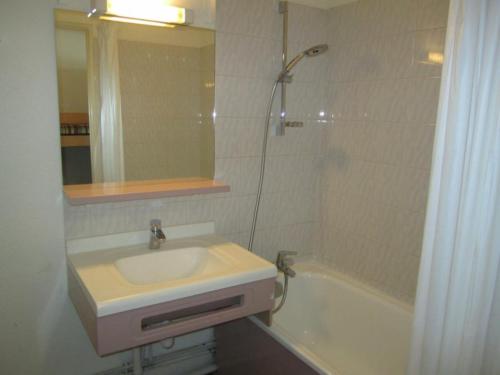 La salle de bains est pourvue d'un lavabo, d'un miroir et d'une baignoire. dans l'établissement Studio Brides-les-Bains, 1 pièce, 4 personnes - FR-1-512-132, à Brides-les-Bains