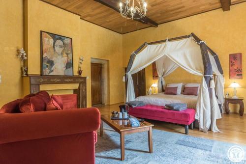- un salon avec un lit et un canapé dans l'établissement Château de Vidaussan, à Labroquère