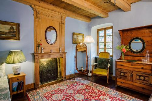 a living room with a fireplace and a chair at Hotel Mas de la Coutettaz, The Farmhouse in Morzine