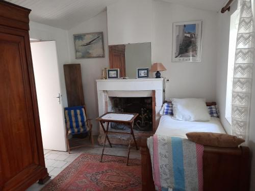 une chambre avec un lit et une cheminée dans l'établissement Maison à l'hortensia, à Sainte-Marie de Ré