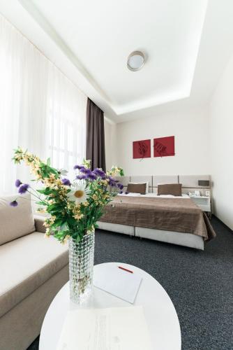 a living room with a vase of flowers on a table at WISH Aqua&SPA Resort in Vishenki