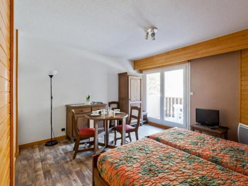 a hotel room with a bed and a table with chairs at Studio Brides-les-Bains, 1 pièce, 4 personnes - FR-1-512-227 in Brides-les-Bains