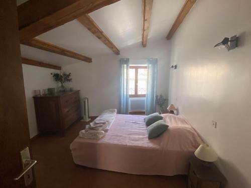une chambre avec un lit dans une pièce avec une fenêtre dans l'établissement Maison de village Chez Mima Valensole, à Valensole