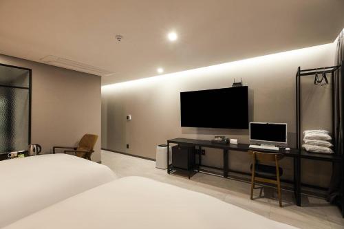 a hotel room with a bed and a flat screen tv at Namyangju Aone Hotel in Namyangju