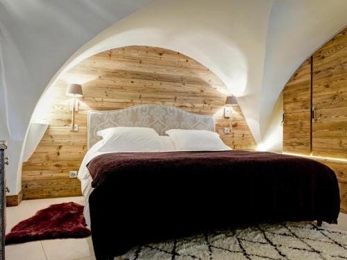 a bedroom with a large bed with a wooden wall at Chalet Courchevel, 5 pièces, 9 personnes - FR-1-514-20 in le Praz
