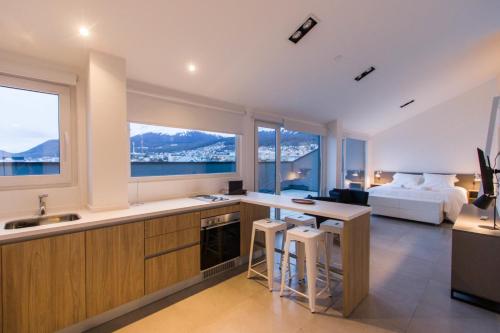 a kitchen and living room with a bed and a table at Austral Departamentos in Ushuaia