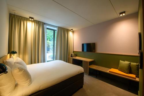a hotel room with a bed and a window at Hotel & Wellness Zuiver in Amsterdam