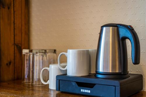a coffee maker and two cups on a table at George and Dragon Dent in Dent