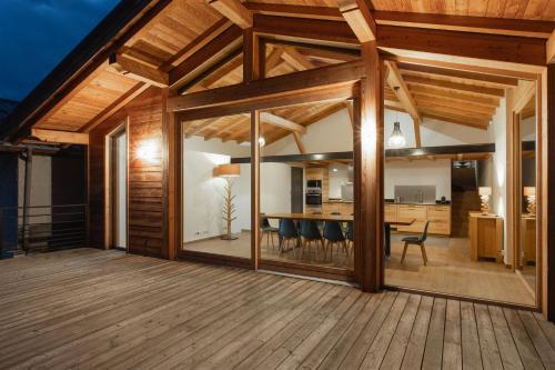 salón comedor de planta abierta con terraza de madera en CHALET ALTAÏ, en Séez