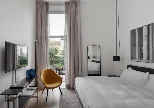 ein Hotelzimmer mit einem Bett, einem Stuhl und einem Fenster in der Unterkunft BB Hotels Aparthotel Collection Il Michelangelo in Florenz