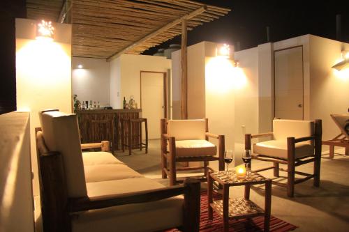 a room with chairs and a table with a candle at Bamboo Lodge Paracas in Paracas