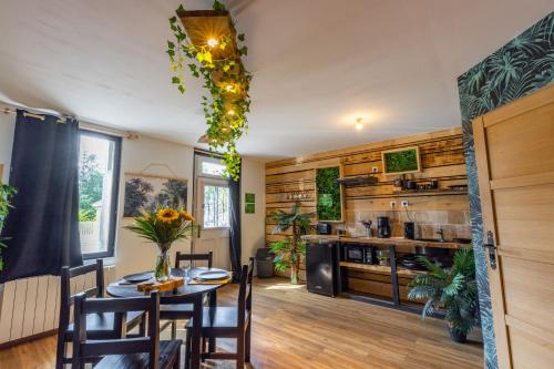 Un comedor con una mesa y una cocina. en L'Amazonia - Domaine Tropical, en Saint-Aignan