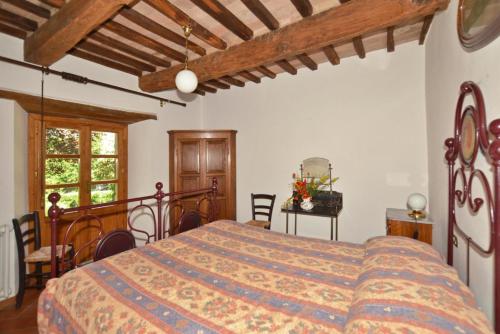 1 dormitorio con cama y techo de madera en Villa Piombona, en Anghiari