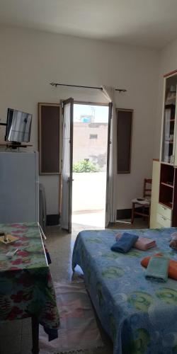 a bedroom with two beds and a sliding glass door at appartamento celeste in Pantelleria