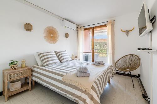 een witte slaapkamer met een bed en een raam bij Le Val d'Ore par Dodo-a-Cassis in Cassis