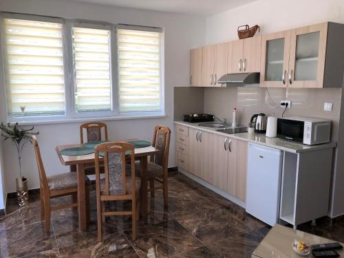 małą kuchnię ze stołem i kuchenką mikrofalową w obiekcie Apartman Pino w mieście Veliko Gradište