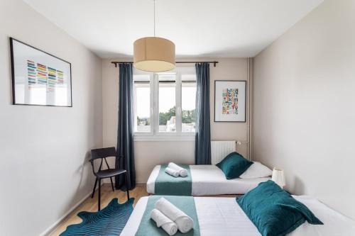 une chambre avec deux lits et une fenêtre dans l'établissement Blanche de Castille- Rond point de Paris, à Nantes